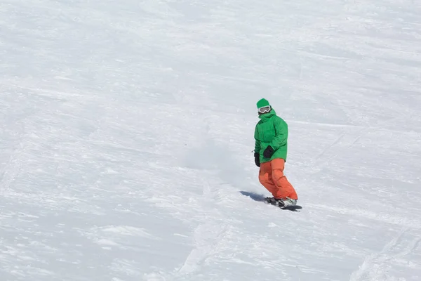 Snowboardåkare snowboard på färsk vit snö med skidbacken på solig vinterdag — Stockfoto