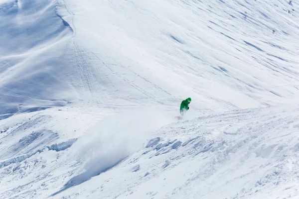 Snowboarder snowboard en nieve blanca fresca con pista de esquí en el soleado día de invierno —  Fotos de Stock