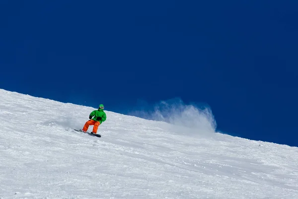 Snowboarder snowboardozás a friss fehér hó a sípálya a napsütéses téli nap — Stock Fotó