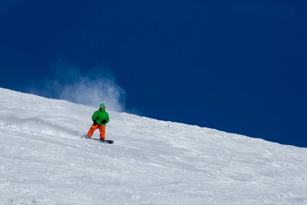 Snowboarder snowboard en nieve blanca fresca con pista de esquí en el soleado día de invierno —  Fotos de Stock