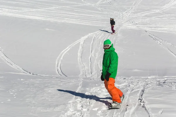 Snowboarder snowboardozás a friss fehér hó a sípálya a napsütéses téli nap — Stock Fotó