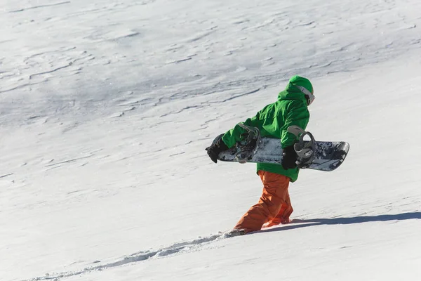 Snowboarder Snowboard auf Neuschnee mit Skipiste an sonnigem Wintertag — Stockfoto