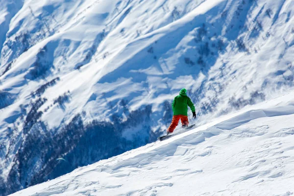 Snowboarder snowboard en nieve blanca fresca con pista de esquí en el soleado día de invierno Fotos de stock libres de derechos