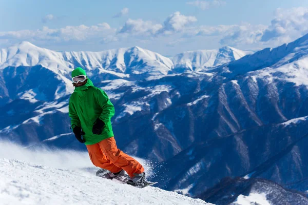 Snowboarder snowboarden op verse witte sneeuw met skihelling op zonnige winterdag Stockafbeelding