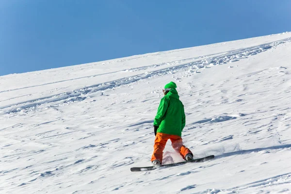 Snowboarder σνόουμπορντ στο φρέσκο χιόνι λευκό με πίστα σκι, ηλιόλουστη χειμερινή ημέρα — Φωτογραφία Αρχείου