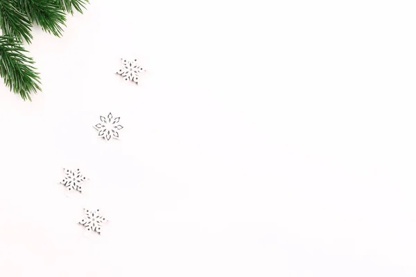 Χριστουγεννιάτικη σύνθεση από κλαδιά ελάτης και νιφάδες χιονιού σε λευκό φόντο. μινιμαλιστική έννοια διακοπών — Φωτογραφία Αρχείου