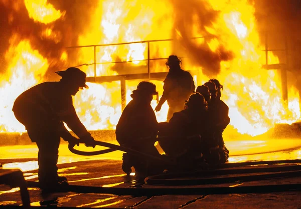 Пожарный настраивает пожарный шланг во время учений — стоковое фото