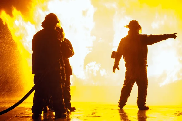 Capo dei pompieri che indica la destra durante l'esercitazione antincendio Immagine Stock
