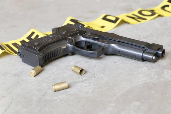 Концепция места преступления с пистолетом и тремя гильзами Стоковое Изображение