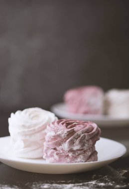 Siyah arka planda beyaz ve pembe şekerlemeler.