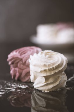 Siyah arka planda beyaz ve pembe şekerlemeler.