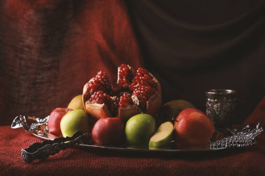 Nar ve elmalarla dolu karanlık bir arka planda hayat