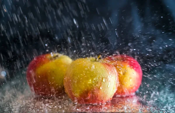 Red apples are in the water spray — Stock Photo, Image