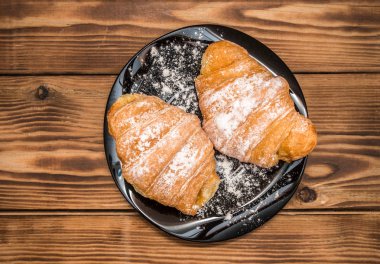 Siyah bir plaka üzerinde taze kruvasanlar