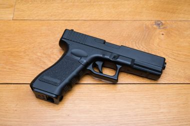 Siyah ahşap arka plan üzerinde tabanca