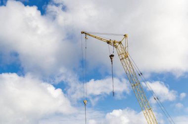 Bulutlar üzerinde sarı inşaat vinç