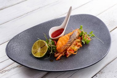 Domatesli kızarmış somon, limon, baharat ve sos.