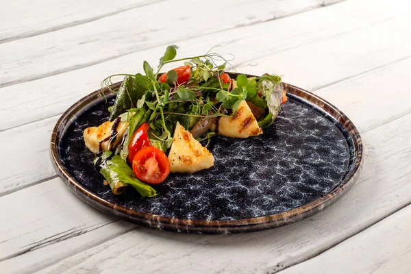 Salada com queijo grelhado, tomates e verde em uma madeira branca — Fotografia de Stock