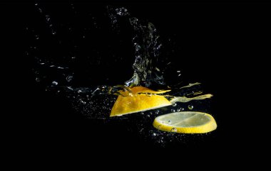 Siyah arkaplanda suya limon sıçratma