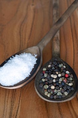 Tahta kaşıklarda deniz tuzu ve karışık karabiber.