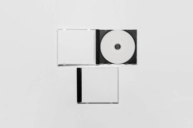 Marka tasarımı için beyaz izole edilmiş boş bir kutu ile kompakt plastik disk kutusu açılıp kapatılıyor. Cd mücevheri, yumuşak gri arka planda. Dvd veya CD diski