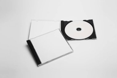 Marka tasarımı için beyaz izole edilmiş boş bir kutu ile kompakt plastik disk kutusu açılıp kapatılıyor. Cd mücevheri, yumuşak gri arka planda. Dvd veya CD diski