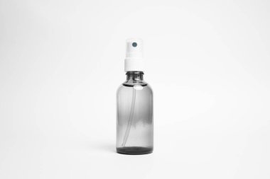 Beyaz sprey başlıklı cam şişeyi temizle. Beyaz arka planda izole edilmiş. Boş Ambalaj Mockup.Yüksek çözünürlüklü fotoğraf..