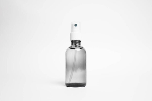 Clear Glass Bottle with a white spray nozzle. Isolated on white background. Blank Packaging Mockup.High-resolution photo.Spray bottle.