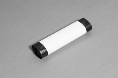 Gri arka planda siyah çöp torbası. Yüksek çözünürlüklü fotoğraf..