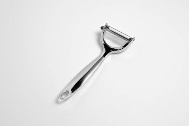 Paslanmaz çelik soyucu beyaz arka planda izole edilmiş. Patatese karşılık bıçak. Mutfak eşyaları. Yüksek çözünürlüklü fotoğraf.