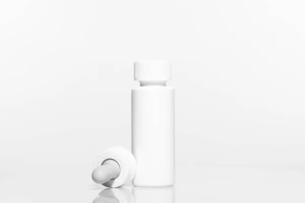白色底座上有滴水器盖的空白塑料瓶 塑料瓶包装模型集准备为您的设计 高分辨率照片 — 图库照片