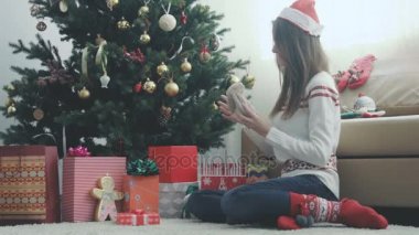 Genç güzel kız bir Noel hediyesi sarar