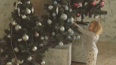 Parmak Noel topları dekore edilmiş ağaç üzerinde küçük sevimli kız puanla