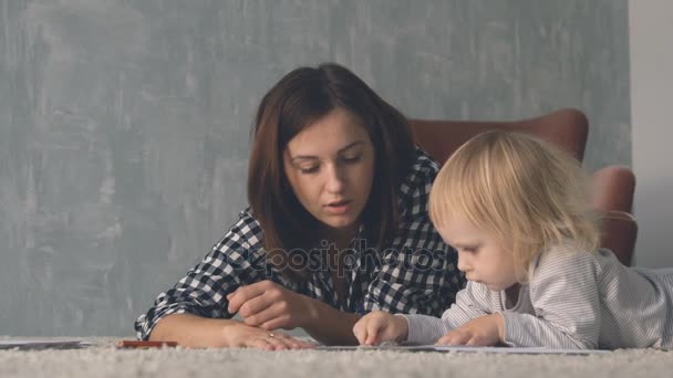 Mor med lilla bebis ritar med färgglada pennor — Stockvideo