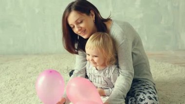 Anne ve küçük kızı oynuyor balonlarla