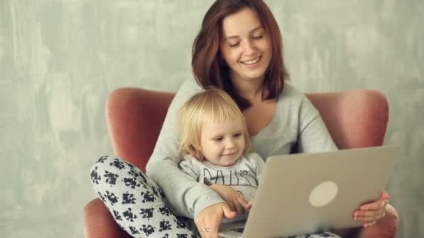 Beautiful mother with little daughter using laptop — Stock Video