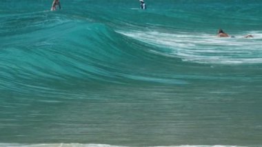 Okyanus dalgaları üzerinde yüzen sörfçü