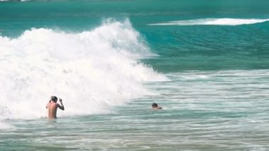 İnsanlar okyanus dalgaları arasında