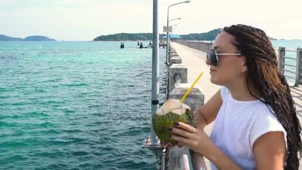 Mujer bonita bebe leche de coco en el muelle — Vídeos de Stock