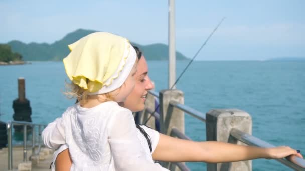 Madre con hija pequeña mirando lejos en el océano — Vídeos de Stock