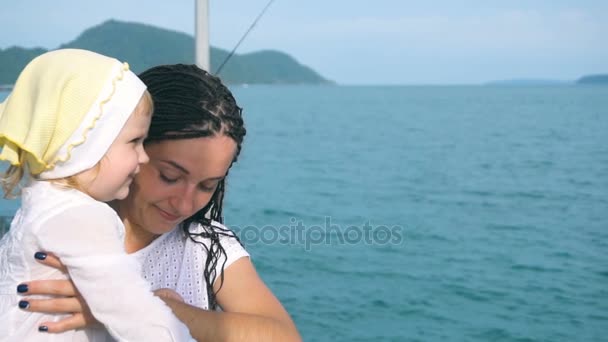 Madre con hija pequeña mirando lejos en el océano — Vídeo de stock