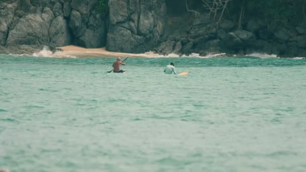 Skilled surfer explain something to his partner in the ocean — Stock Video