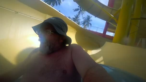 Starszy mężczyzna jazda w tubie aquapark — Wideo stockowe