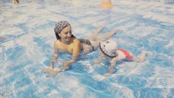 Mother crawling in pool with daughter — Stock Video