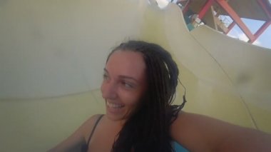 Neşeli kız waterpark slayt üzerinde sürmek