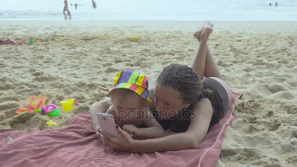 Мама играет с маленькой дочерью с помощью смартфона — стоковое видео