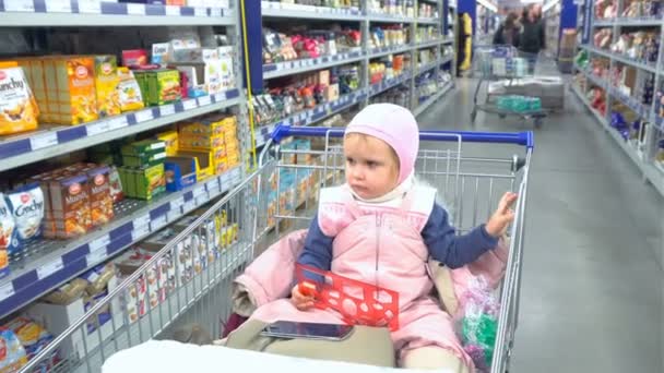 Criança entediada esperando os pais no supermercado — Vídeo de Stock