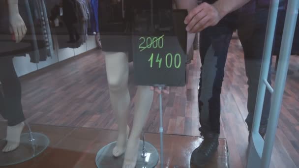 Shop assistant establishes the sign with information about discount — Stock Video