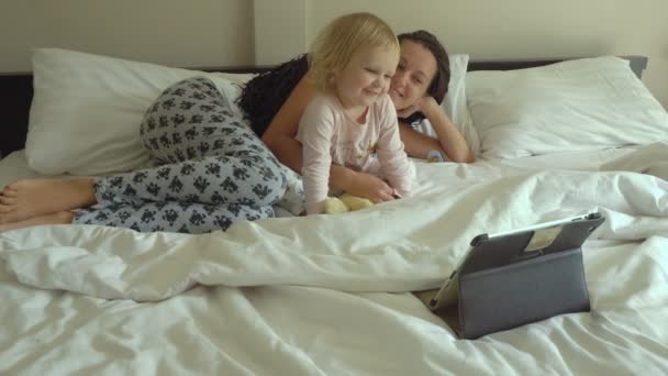 Мать и дочь смотрят мультики на планшетном компьютере — стоковое видео
