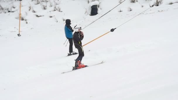 スキーヤーはドラッグ リフトで山を登っています。 — ストック動画